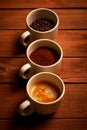 Three cups of espresso, freshly ground coffee and coffee beans on a wooden table Royalty Free Stock Photo
