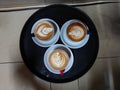 Three cups of hot cappuccino coffee served on a black tray Royalty Free Stock Photo