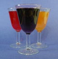 Three cups of cocktails mimosa, red wine and cabernet a blue background from a lateral view Royalty Free Stock Photo