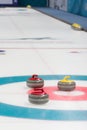 A vertical picture of curling stones on top of curling sheet. Royalty Free Stock Photo