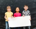 Three cute children holding an empty paper sheet for ad Royalty Free Stock Photo