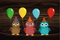 Three cute colored owls sitting on a rope and holding balloons.