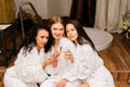 Three cute females in bath robes in the indoor pool. Women friends on vacation at the Spa Royalty Free Stock Photo