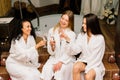 Three cute females in bath robes in the indoor pool. Women friends on vacation at the Spa Royalty Free Stock Photo