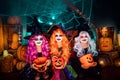 Three cute funny sisters celebrate the holiday. Jolly children in carnival costumes ready for Halloween.