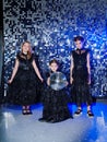 three cute girls in a black long curvy dress dancing at the disco. shiny wall