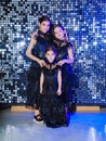 three cute girls in a black long curvy dress dancing at the disco. shiny wall