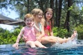 Three cute girls playing in swimming pool Royalty Free Stock Photo