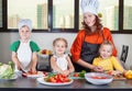 Three cute kids with mom making fruit salad Royalty Free Stock Photo