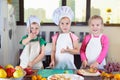 Three cute kids are preparing a fruit salad in kitchen Royalty Free Stock Photo