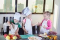 Three cute kids are preparing a fruit salad in kitchen Royalty Free Stock Photo
