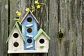 Three cute little birdhouses on wooden fence with flowers Royalty Free Stock Photo