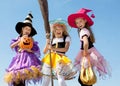 Three Cute Little Witches Standing with Broom