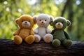 Three cute teddy bears in wite orange and green colors sit on a tree branch with a blurred nature forest background. Can Royalty Free Stock Photo