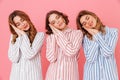 Three cute women 20s wearing colorful striped pajamas sleeping o