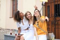 Three cute young girls friends having fun together, taking a selfie at the city Royalty Free Stock Photo