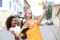 Three cute young girls friends having fun together, taking a selfie at the city Royalty Free Stock Photo