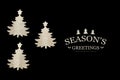 Three cutout Christmas trees on black background with Seasons`s greetings text Royalty Free Stock Photo