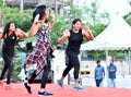 Three dancers performs zumba during marathon warm up session at