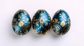 three blue Easter eggs with a blue and gold pattern on a white background, top view Royalty Free Stock Photo