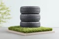 Three Dark Gray Tires Stacked on Artificial Grass Against a Green Background Royalty Free Stock Photo