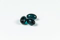 Three dark green soft gelatine capsules.