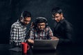 Three dark-skinned guys are chatting in the laptop wearing headphones Royalty Free Stock Photo