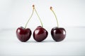 Three darkly cherries on the white table Royalty Free Stock Photo