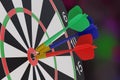 Three darts, blue, red and green, stuck in the center of a target. 3d illustration