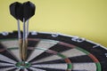 Three darts on bulls eye target of dartboard, concept of victory and goal achievement, selective focus Royalty Free Stock Photo