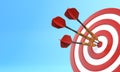 Three darts hitting a red target on the center on blue background with copy space Royalty Free Stock Photo