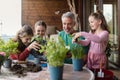 Three daughters helping father to plant flowers, home gardening concept Royalty Free Stock Photo