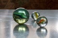 Several decorative glass balls of different size reflecting light on icy surface. Royalty Free Stock Photo