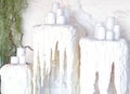 Three decorative huge candlesticks foreground. White wax drips from candles