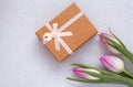 Three delicate pink tulips on white background with gift box Royalty Free Stock Photo