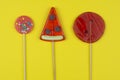 Three delicious candy caramel lollipops bright red on a yellow background Royalty Free Stock Photo