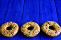 Three delicious donuts on a blue background top view. Place for an inscription. Royalty Free Stock Photo