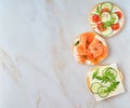 three delicious open sandwiches with salmon, tomatoes, cucumber