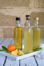 Three delicious yellow alcohol drinks in glass bottles and citrus fruit. Orange-flavored liqueur, Italian Limoncello liquor, tange