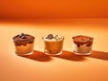 Three desserts in glasses on an orange background