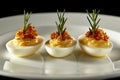 Three Deviled Eggs Garnished with Rosemary and Crumbled Bacon on White Plate, Black Background Royalty Free Stock Photo