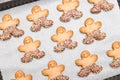 Three diagonal rows of gingerbread men on baking paper.