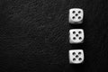 Three dice with fives on a black leather table. Bw photo. Top view