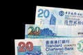 Three different bills in twenty Hong Kong dollars on a dark background