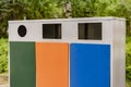 three different colorful metal trash bins or containers, garbage sorting and recycling concepts