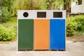 three different colorful metal trash bins or containers, garbage sorting and recycling concepts