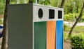 three different colorful metal trash bins or containers, garbage sorting and recycling concepts