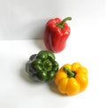 Three different and contrasting colors of green, red and yellow from fresh bell peppers at different angles on a white background Royalty Free Stock Photo