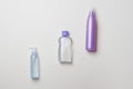 Three different cosmetic bottles lying on diagonal on yellow background Royalty Free Stock Photo
