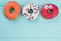 Three different donuts on blue wooden background. Royalty Free Stock Photo